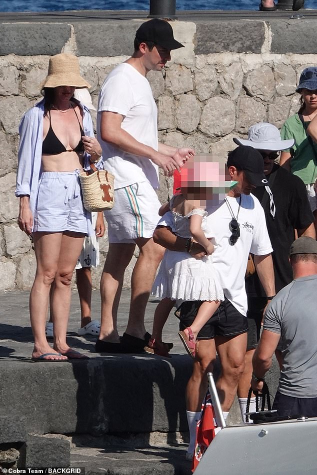 Katy kept a watchful eye as Orlando carried their daughter while hopping aboard the superyacht