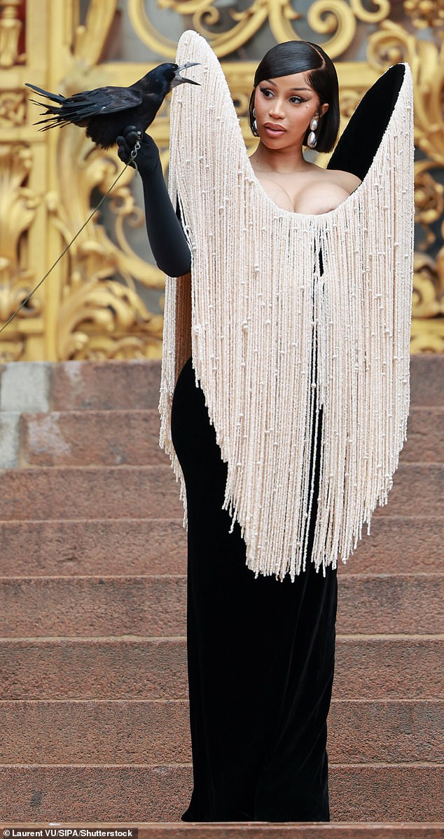 Rapper Cardi B posed for photographers with one black-opera-glove-clad hand clutching a large raven