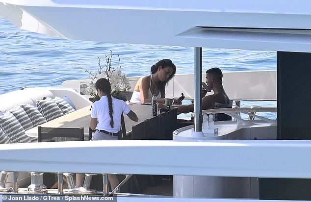 Ronaldo appears to send a voice note on his phone while Georgina scrolls on her own mobile