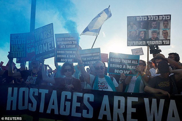A demonstrator holds a smoke flare, during a protest to demand the immediate release of all hostages held in Gaza since October 7, 2023 attack on Israel by Hamas, near the U.S. Consulate in Tel Aviv, Israel, July 7, 2025