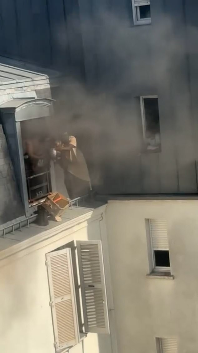 Footage shows him standing next to reaching into the building filled with black smoke, signaling to those inside to pass their children to him