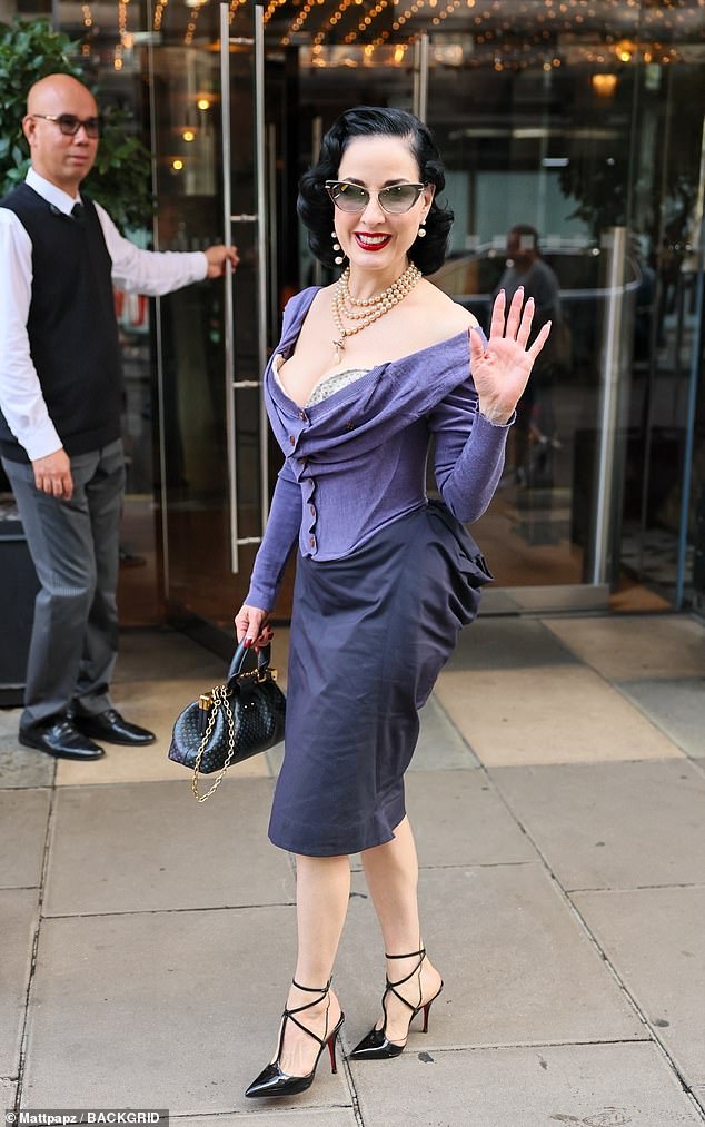 She showed off her famous figure in an eye-catching purple corset and a matching skirt, teamed with stiletto heels