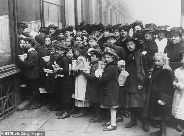 Children and women queuing outside soup kitchens, South London, WWI. Photograph republished during the Second World War
