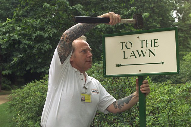 Cockell later became a handyman at Buckingham Palace. He is pictured hammering in a sign ahead of the opening of the Palace's private gardens for the first time in 2001