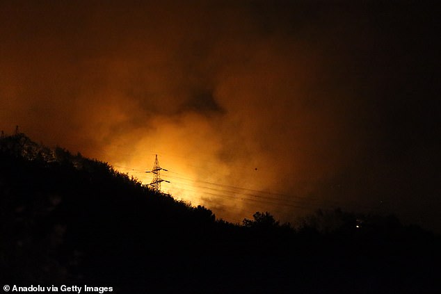 Smoke rises as firefighting teams respond to a forest fire that broke out near residential areas in Dortyol district of Hatay, Turkiye, on July 4, 2025