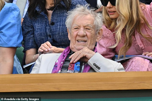 Sir Ian McKellen dressed his greige suit up with colourful scarves as the Lord of The Rings star, 86, watched the game through a pair of binoculars