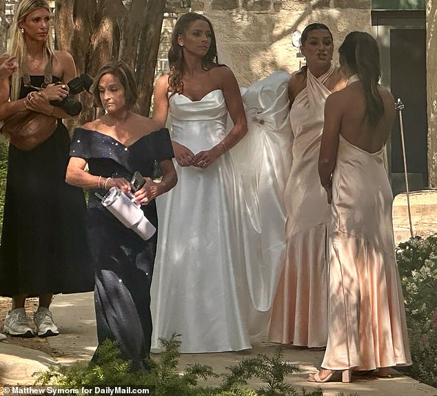 Retton stood with her daughter Emma's 20-something bridesmaids, who all wore coral pink colored dresses, as she got ready to walk down the aisle