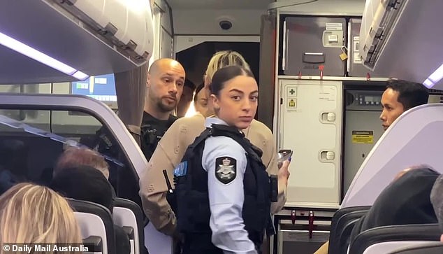 Passengers on the Jetstar flight celebrated as the young woman was marched off the plane