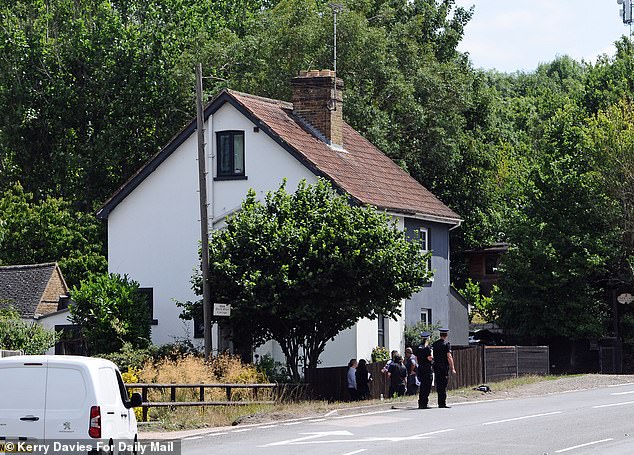Police officers stand outside a property opposite the Park Gate Inn in Hollingbourne, Kent