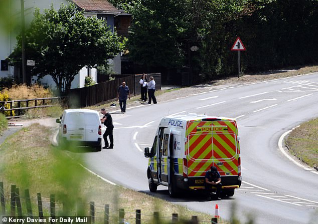 Two police vans parked close to the spot where a man was shot by armed police after wielding a chainsaw