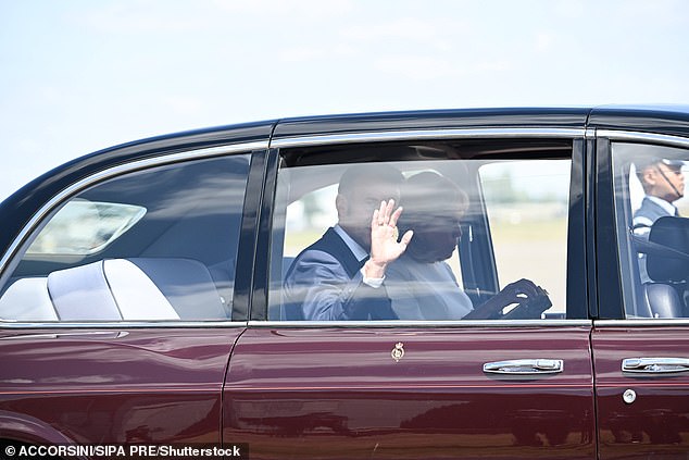 Emmanuel Macron waves as his wife looks down following their arrival at Northolt yesterday