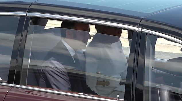 Emmanuel Macron sits next to his wife in a car at RAF Northolt after their welcome yesterday