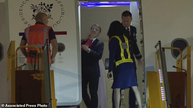 Mrs Macron appeared to stick out both her hands and give her husband's face a shove