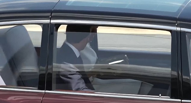 Brigitte Macron then starts looking at her mobile phone while sat next to the President