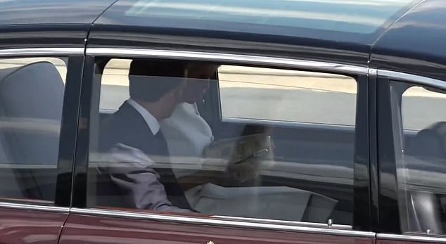 The couple appear to remain frosty in the car as Brigitte Macron looks inside her handbag