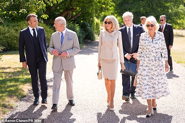Mr Macron, King Charles, Mrs Macron and Queen Camilla stroll through the grounds of Windsor Castle accompanied by aides