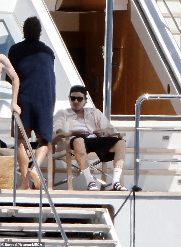 Brooklyn took it easy in the shade wearing an open shirt and shorts