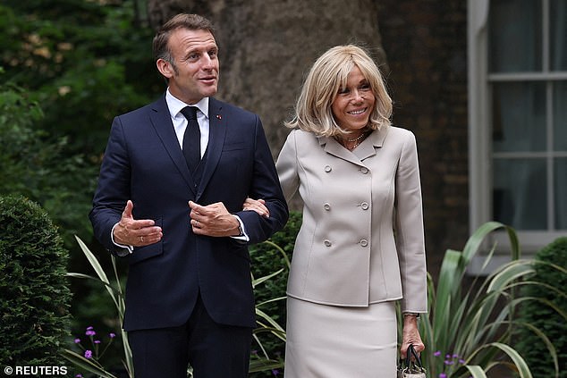 After being filmed apparently shunning her husband's offer of help as she disembarked the plane as they arrived in the UK, Mrs Macron also took her husband's arm after they arrived.