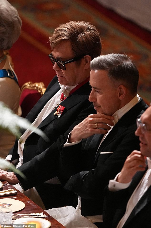 Meanwhile, Elton donned a pair of shades for the evening as he was seated next to his husband David