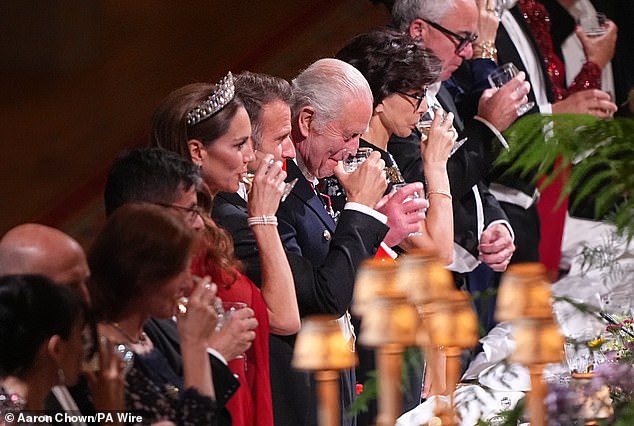 King Charles appeared to giggle as he sipped on his drink. Both he and President Macron delivered speeches