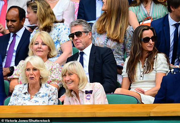 Camilla enjoys yesterday’s action on Centre Court in front of Hugh Grant