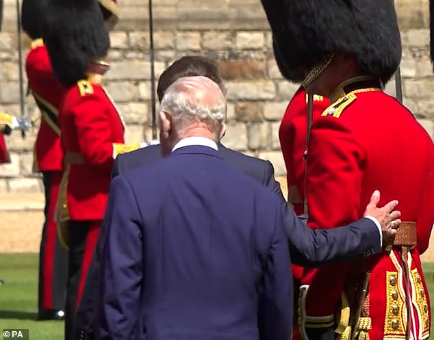 While Macron walking alongside the Grenadier Guard, and ahead of the King, the president patted the guards captain on the back