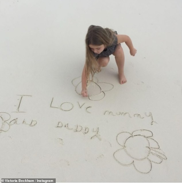 Victoria shared another photo of Harper on the beach where she wrote in the sand: 'I love mummy and daddy'