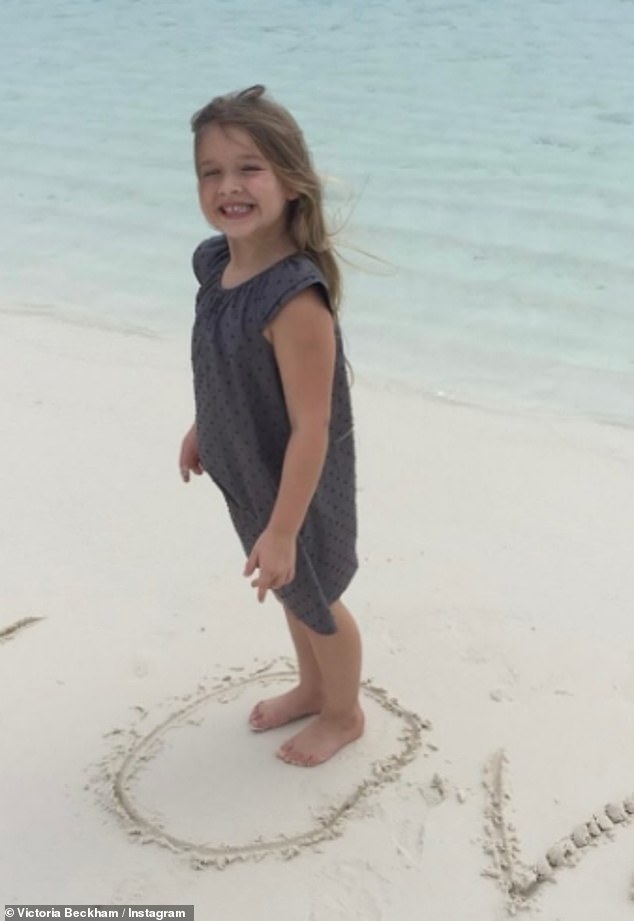 In one photo, Harper posed on the beach after scrawling the word 'LOVE' in the sand