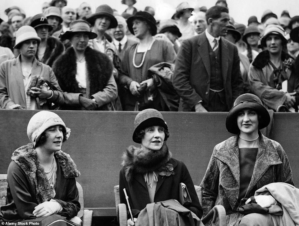 Elizabeth, Duchess of York, sits in a box with two friends and watches her husband George VI, Duke of York, and Wing Commander the Honourable Louis Greig playing tennis against H. Roper Barrett and A.W. Gore at the Wimbledon Championships, 1926