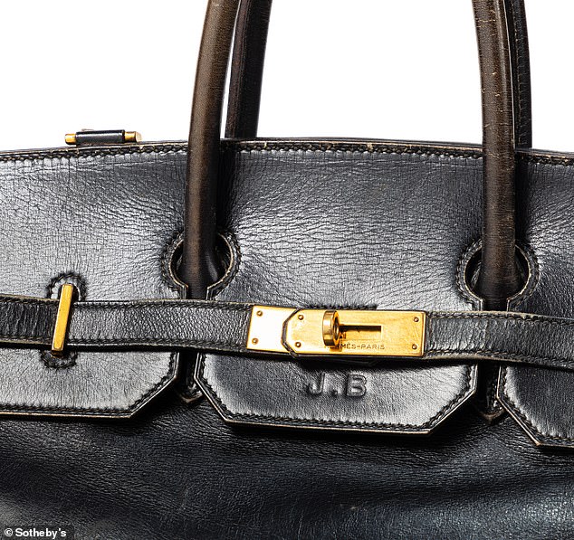 Jane's initial, 'J.B' are embossed on the front and it and bears the residue of Unicef and Médecins du Monde stickers stuck on the front and sides by Jane. It also has a gold clasp and unlike subsequent versions, has a shoulder strap