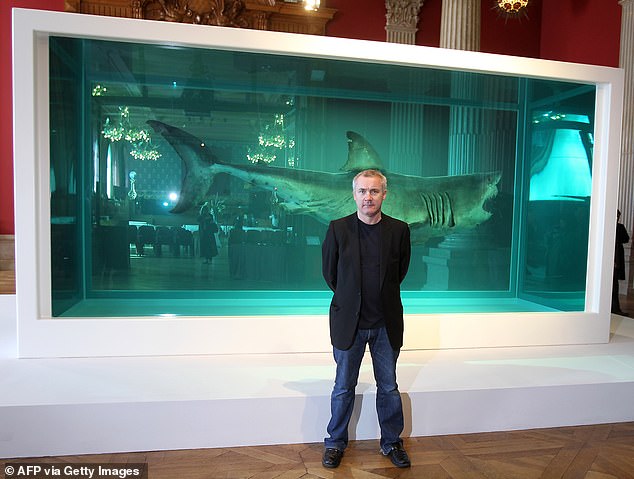 Hirst poses before his creation "The immortal" (1999) representing a white shark, on March 29, 2010 at the Oceanography Museum in Monaco