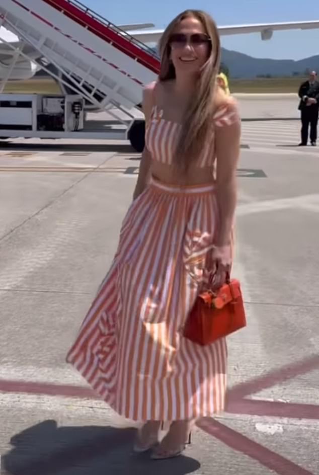 On Thursday the perfume mogul was seen in a cheerful mood while wearing a bra top and matching skirt with high heels as she headed to an airplane
