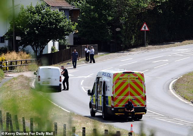 Two police vans parked close to the spot where a man was shot by armed police after wielding a chainsaw