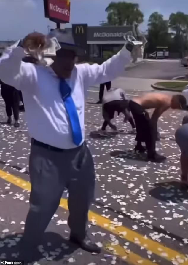 Mourners and bystanders scramble to collect money falling from the sky during the emotional tribute