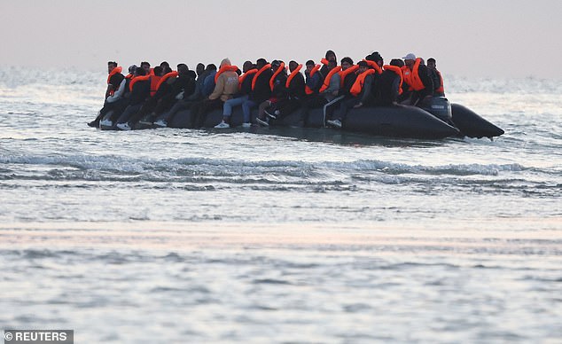 Migrants sit on an inflatable dinghy as it sails along the coastline near Gravelines on Thursday
