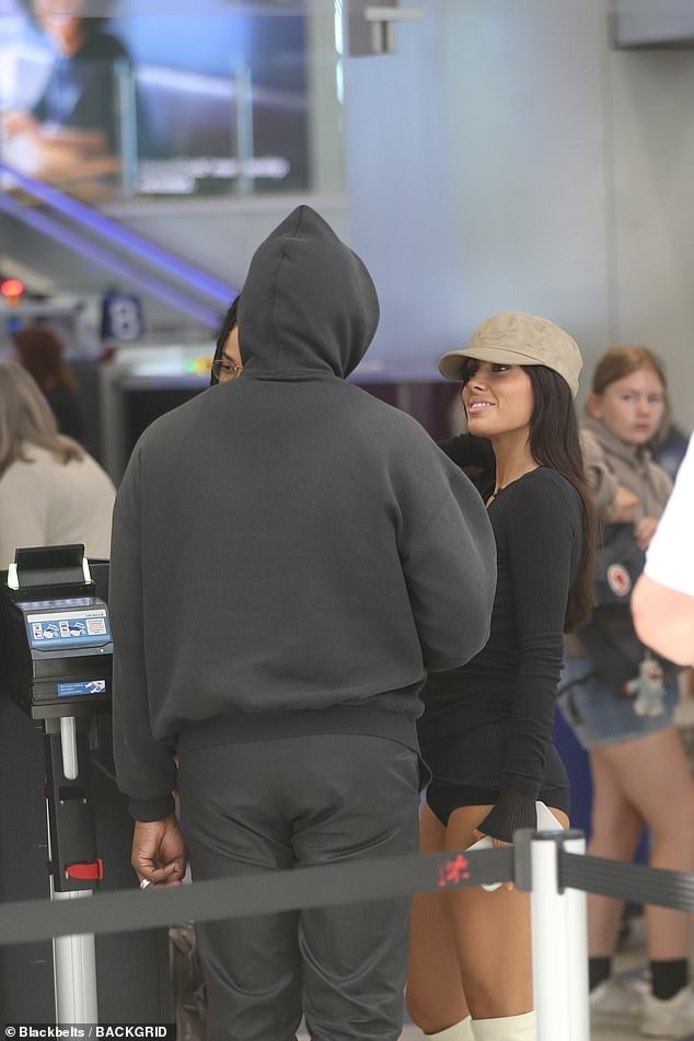 The couple made their way through the line and a TSA worker was seen checking the controversial rapper's passport to identify him