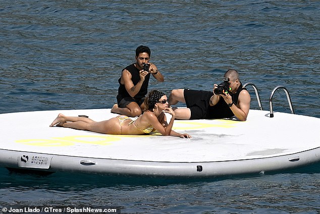 In one shot the star lay on her front as two photographers were seen lying beside her in a behind the scene shot
