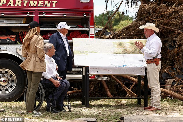 President Donald Trump, first lady Melania Trump and Texas Governor Greg Abbott receive a briefing from a first responder as they visit flood-damaged areas
