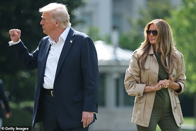 President Trump raises his fist as Melania Trump stands by him