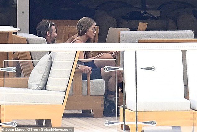 Curtis stroked Aniston's locks as she rested her hand on his leg