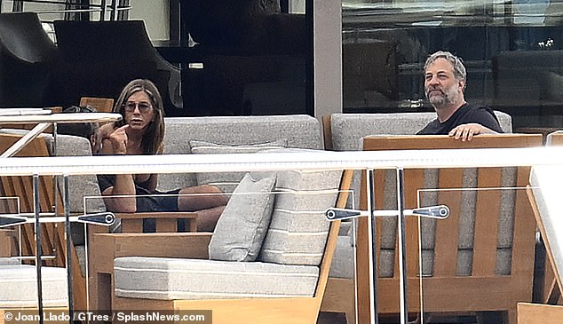Curtis wrapped an arm around Aniston as they chatted with director Judd Apatow