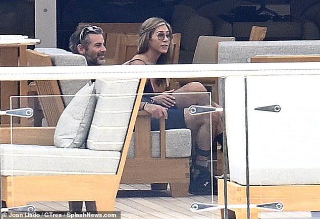 Aniston placed a hand on Curtis' leg during an intimate chat