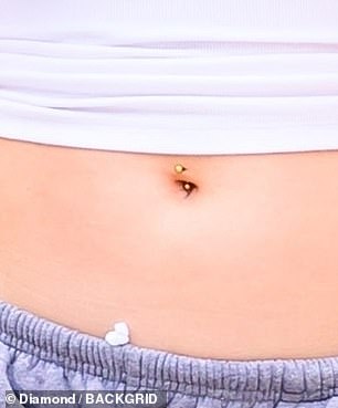 Suri's mom Katie does not seem to have a belly piercing, but does have a nose piercing
