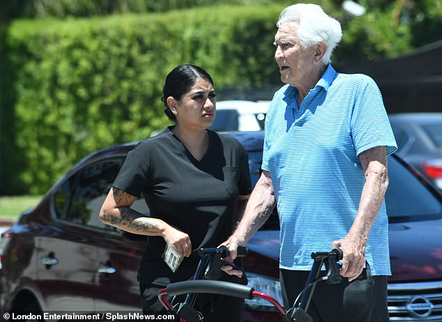 Dressed in a light blue polo and black pants, the Golden Globe-nominated actor kept a careful pace, even leaning on his nurse at one point as he made his way down the sidewalk