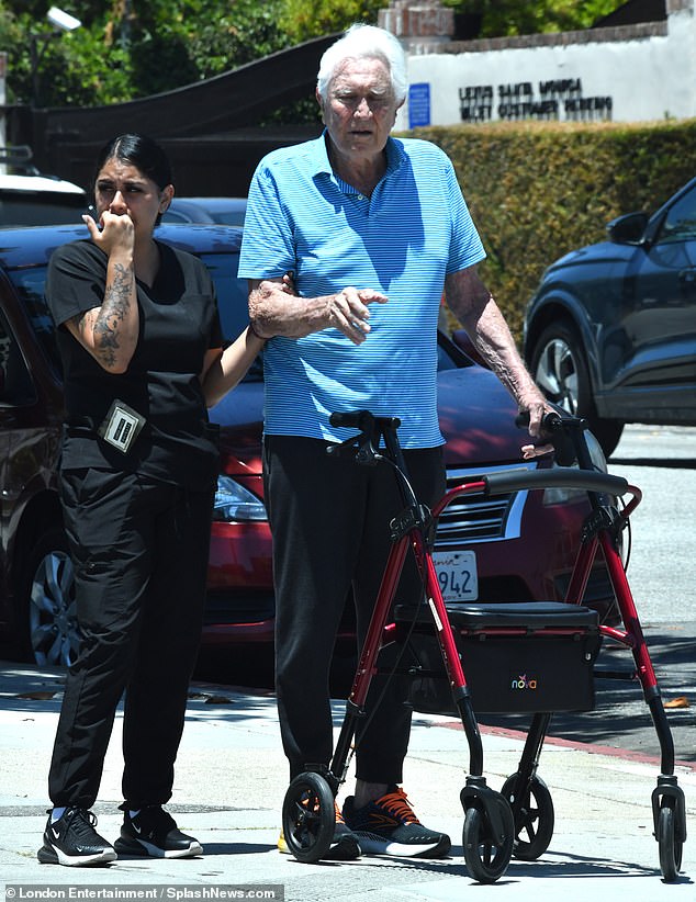 The Australian actor, 85, appeared frail as he relied on a walker during a sunny afternoon outing, with a nursing aide staying close by his side
