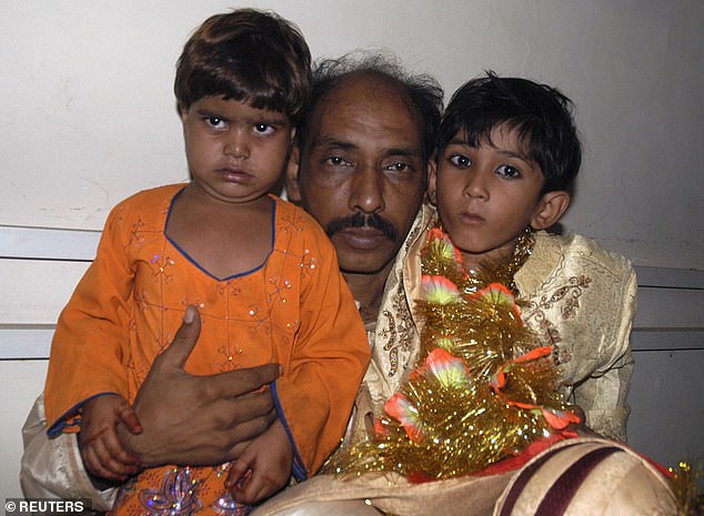 Seven-year-old groom Mohammad Waseem (R) sits with his four-year-old bride Nisha (L) and his father Mohammad Ismil in a police station in Karachi October 31, 2008