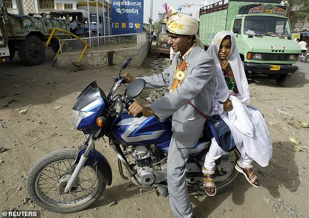 Mamta, 9, rides pillion with her groom Ram Singh, 14, after their wedding in Biaora, in India's central Madhya Pradesh state, April 22, 2009