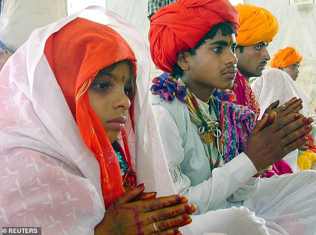 A child bride, Sheela, 8, sits besides her fourteen-year-old groom Daulat Ram (2nd L) during their marriage ceremony at Rajgarh district in the central Indian state of Madhya Pradesh, 2003