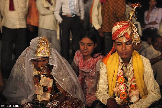 Hemant (R), 16, sits with his 13-year-old newly wed wife Saraswati in a mass marriage outside his village near Kota in the northwestern state of Rajasthan, May 17, 2010