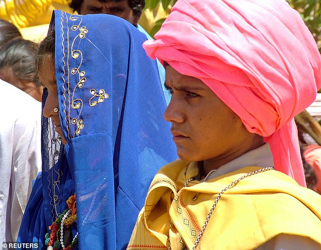 Inder Singh (R), 14, and his bride Ram Bai, 13, stand outside a temple during their marriage near Bhopal, India in 2005